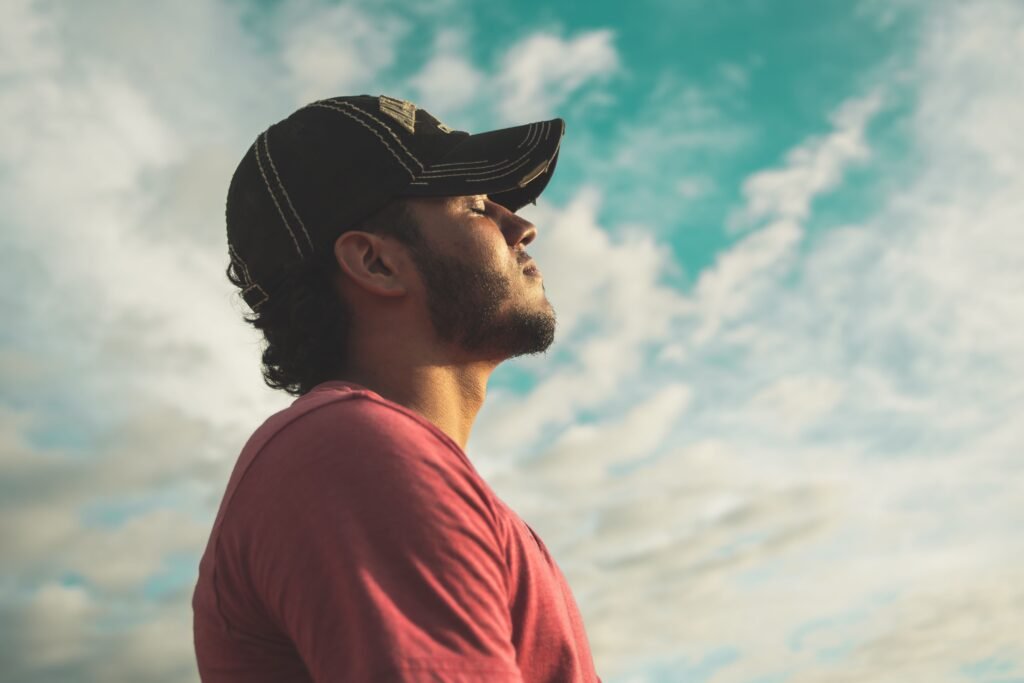 Photo by Kelvin Valerio: https://www.pexels.com/photo/man-wearing-black-cap-with-eyes-closed-under-cloudy-sky-810775/